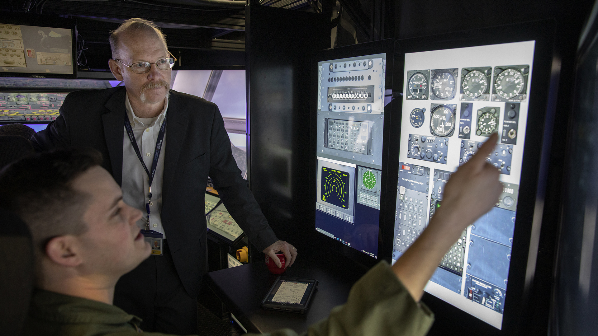 photo - two men looking at high-tech monitors