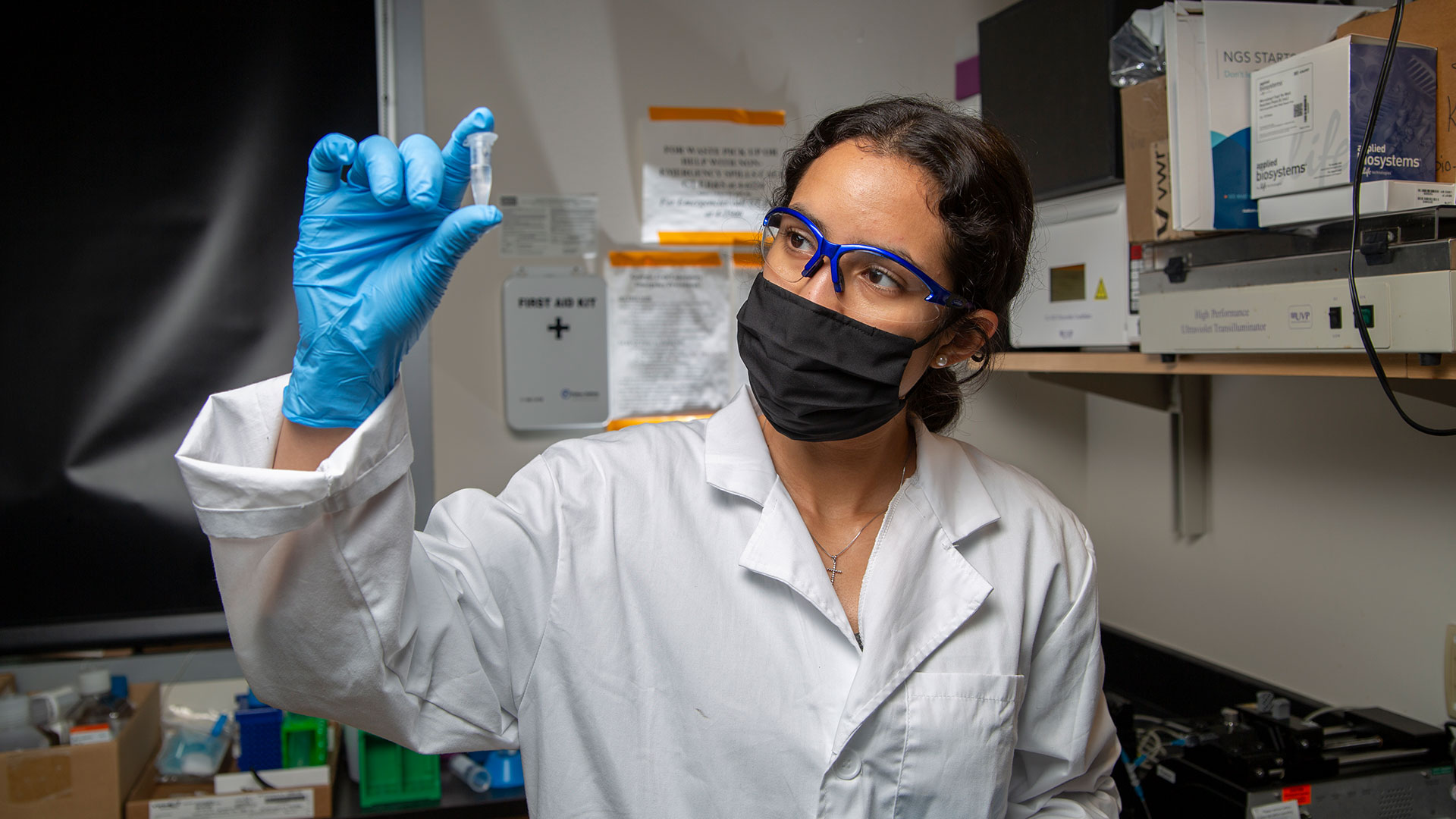 Nina Sara Fraticelli-Guzman holds up a small vial of fluid.