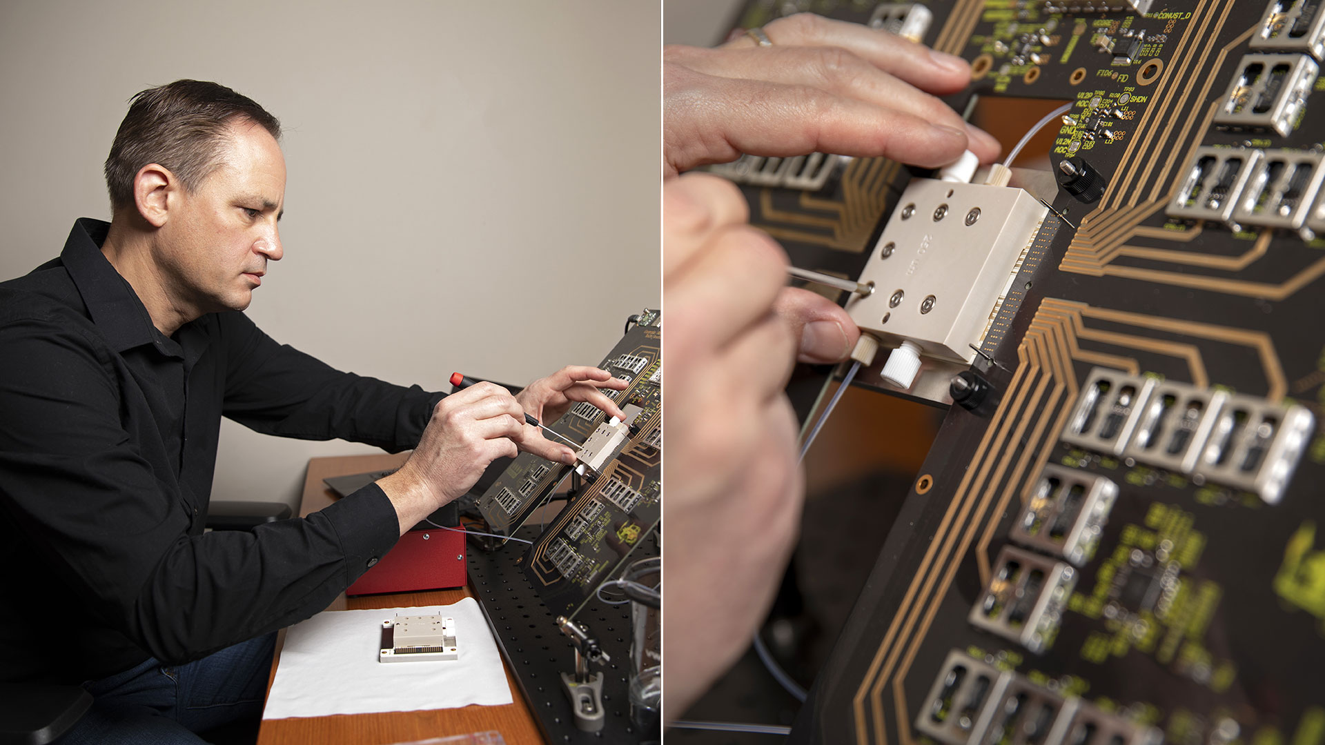 Researcher sitting at desk adjusting device with small tool.