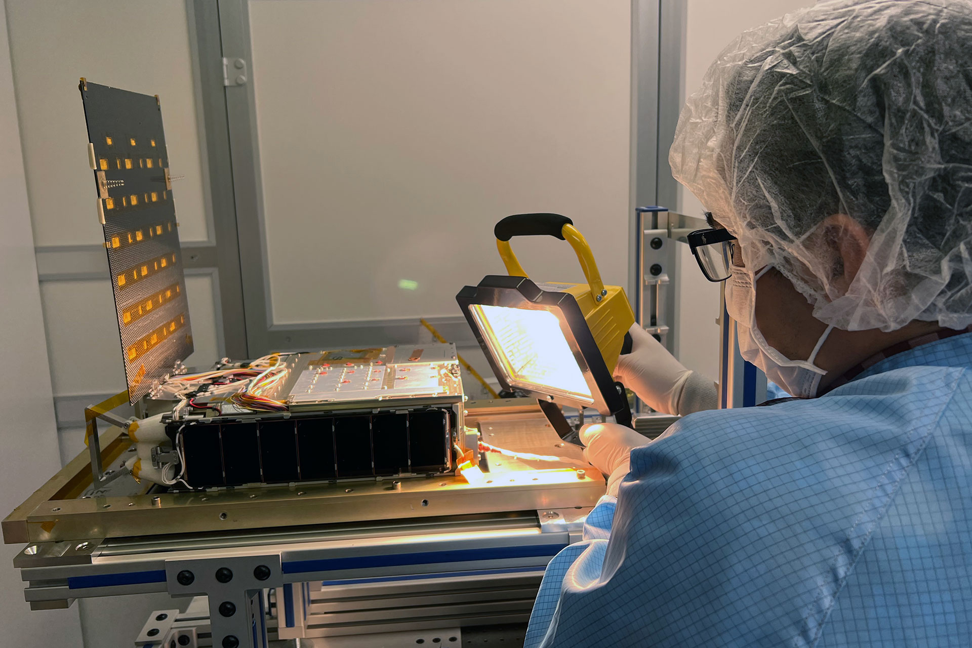 Researcher examining testing device in lab.