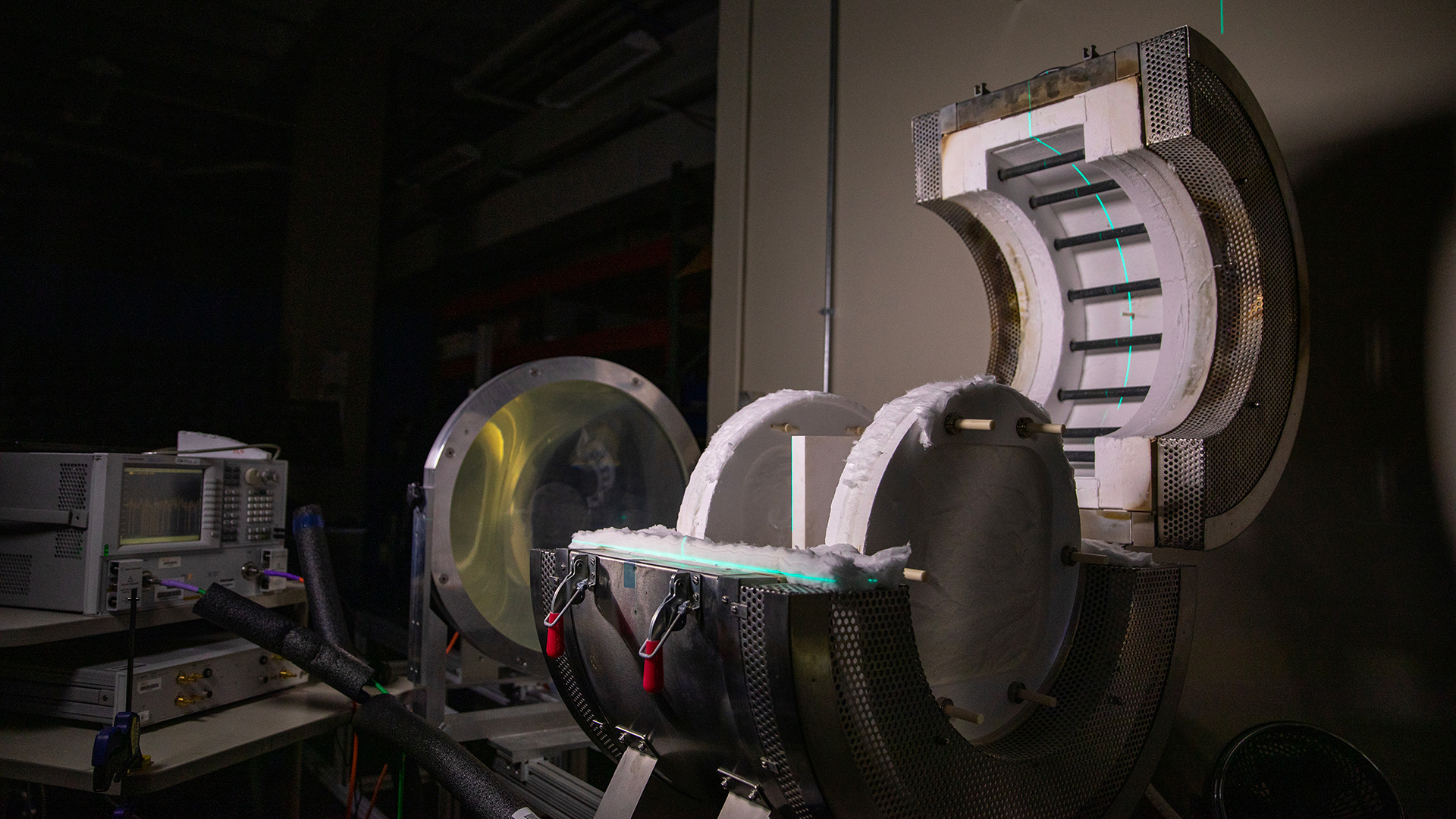 Dark test lab room with large furnace device with lid open