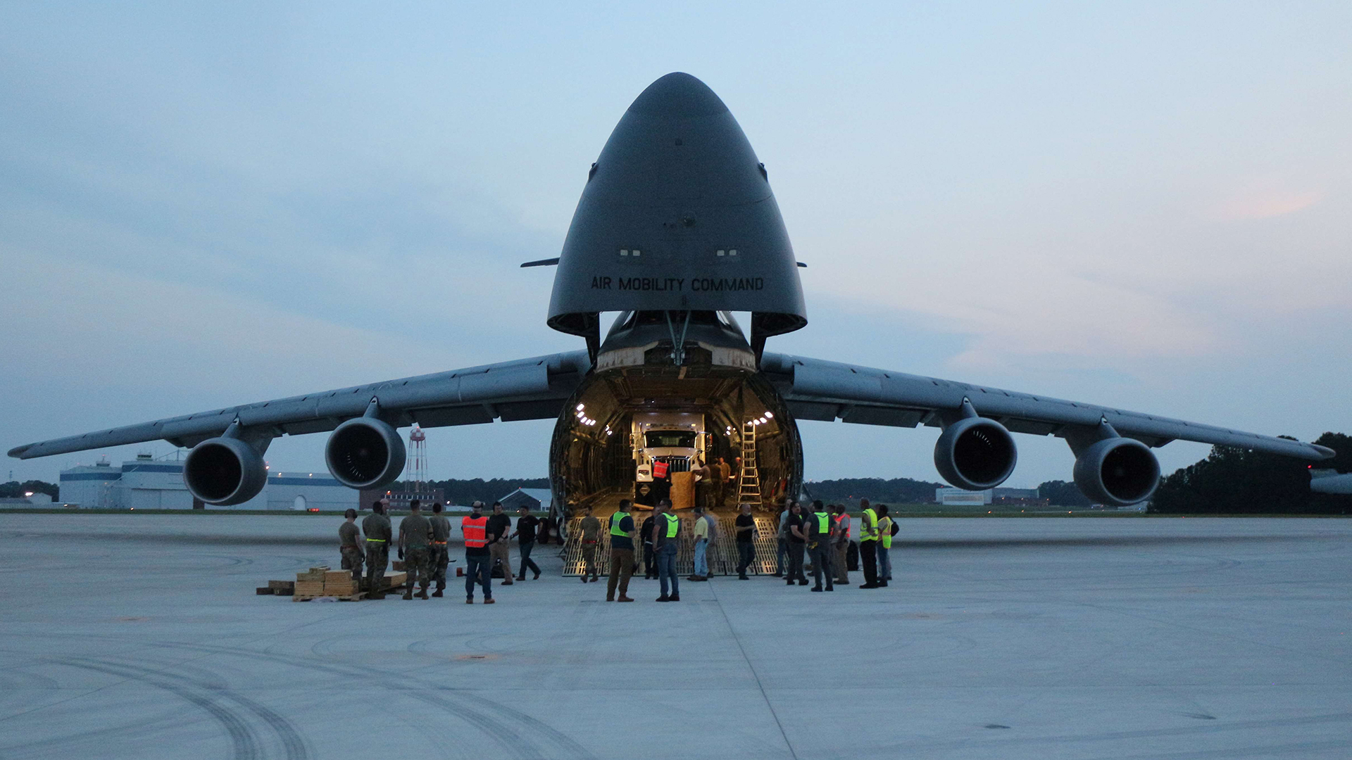 Crew standing in front of open nose of aircraft with semi truck containing ARTS-V1 system inside.