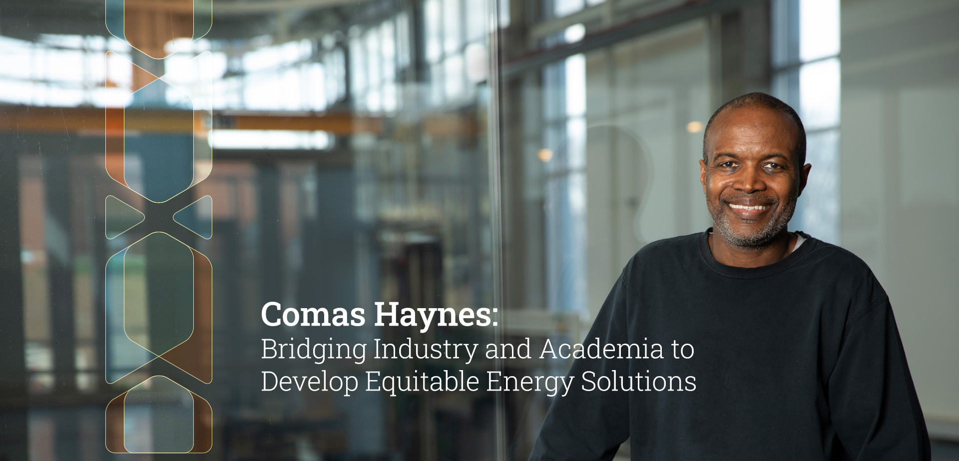 Comas Haynes seated within a glass office that overlooks a manufacturing facility