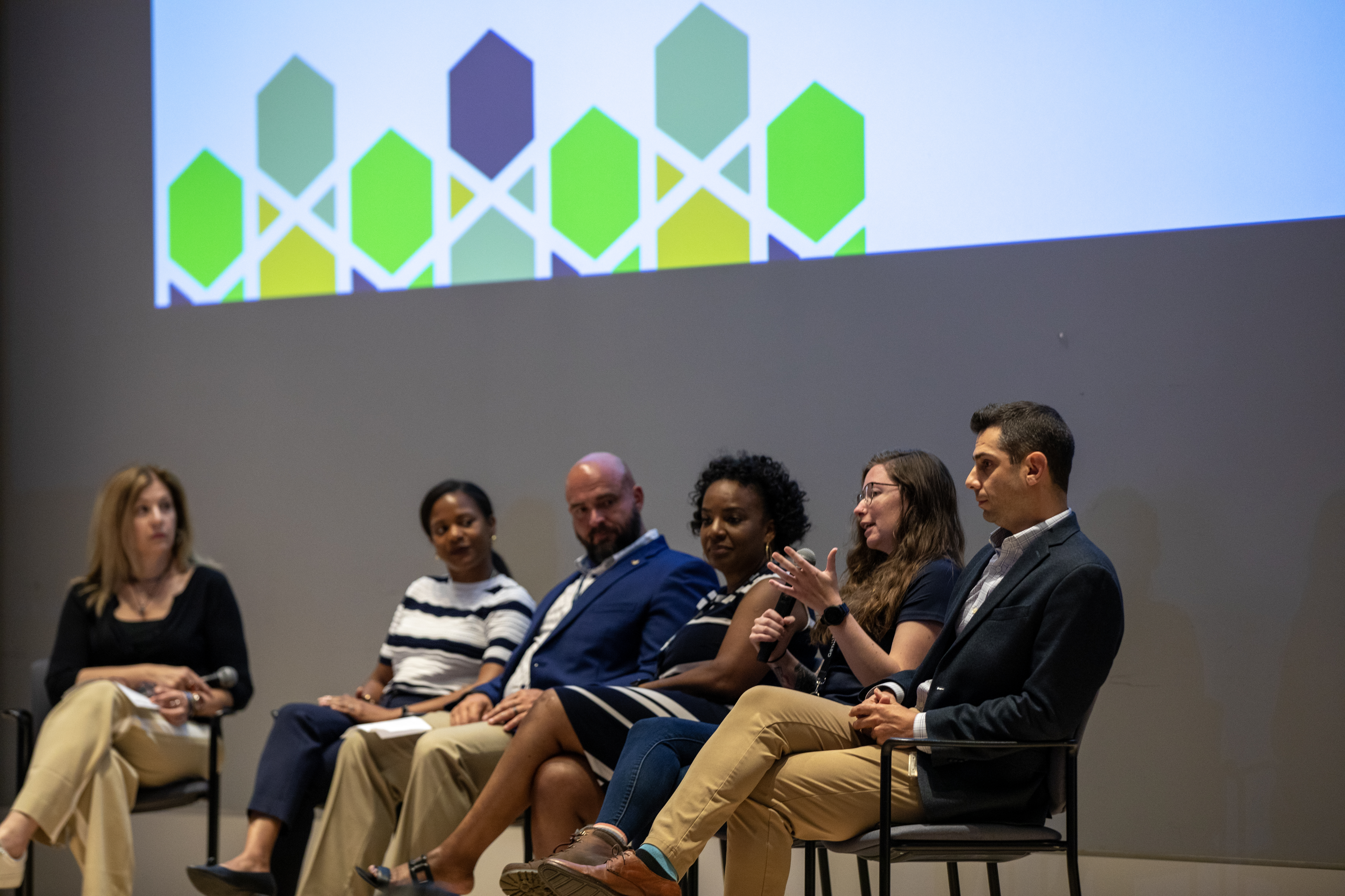 panelists on stage at a conference 