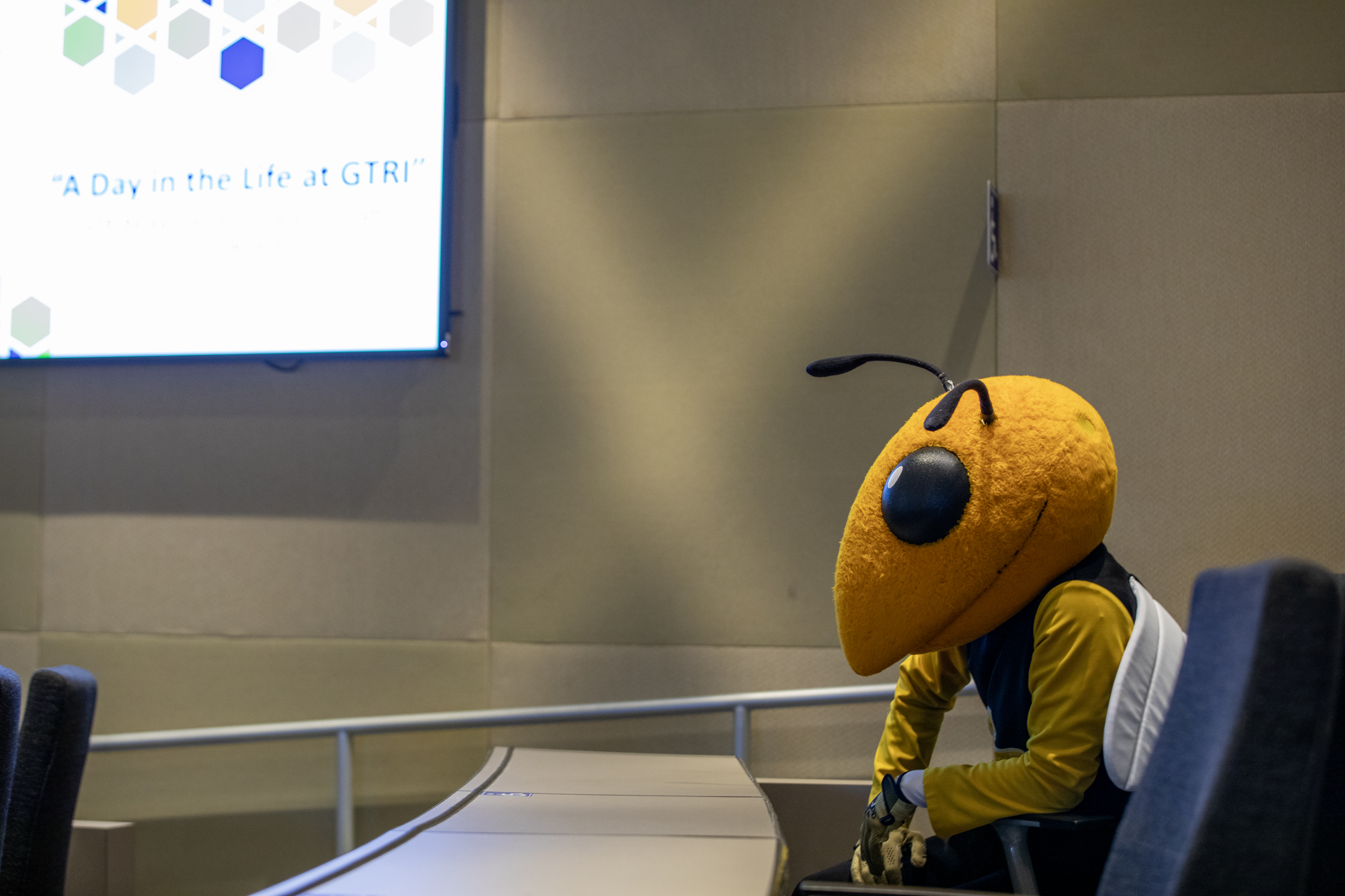 Buzz mascot sitting in conference room
