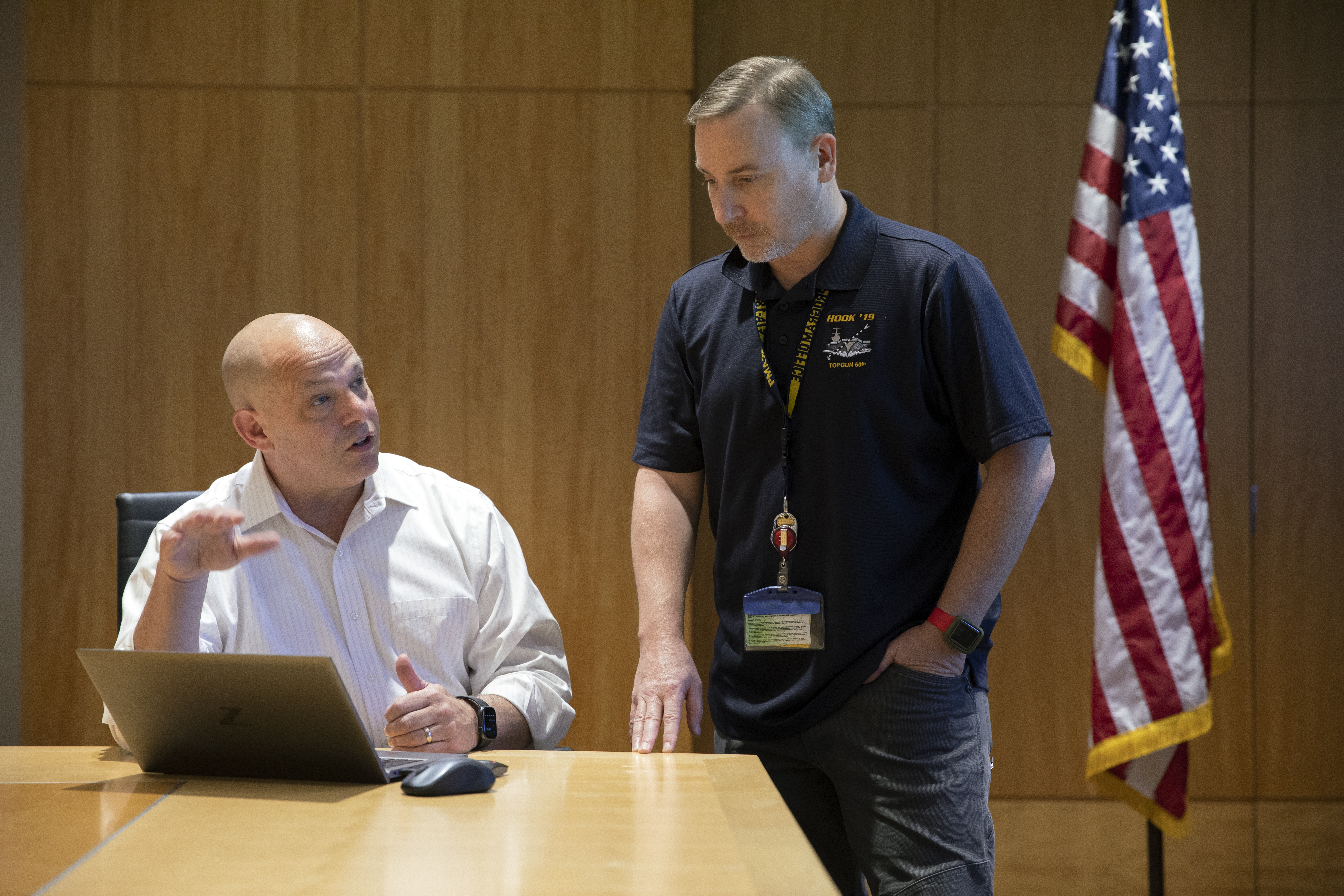 Erik Andersen sitting at a table and talking with JD Fassett.