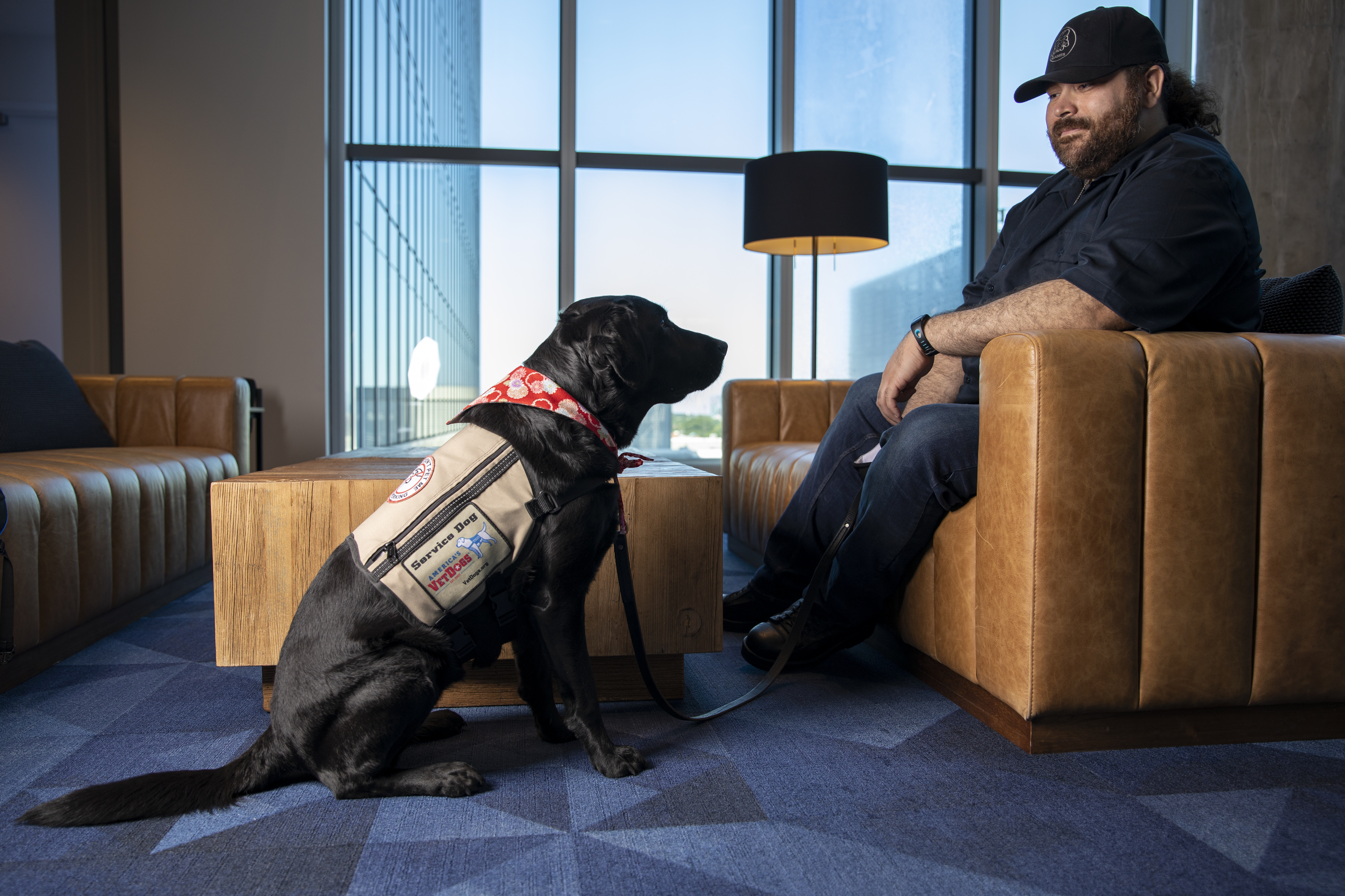 GTRI Research Associate Alex Montañez sits with his service dog Willow. (Photo Credit: Sean McNeil)