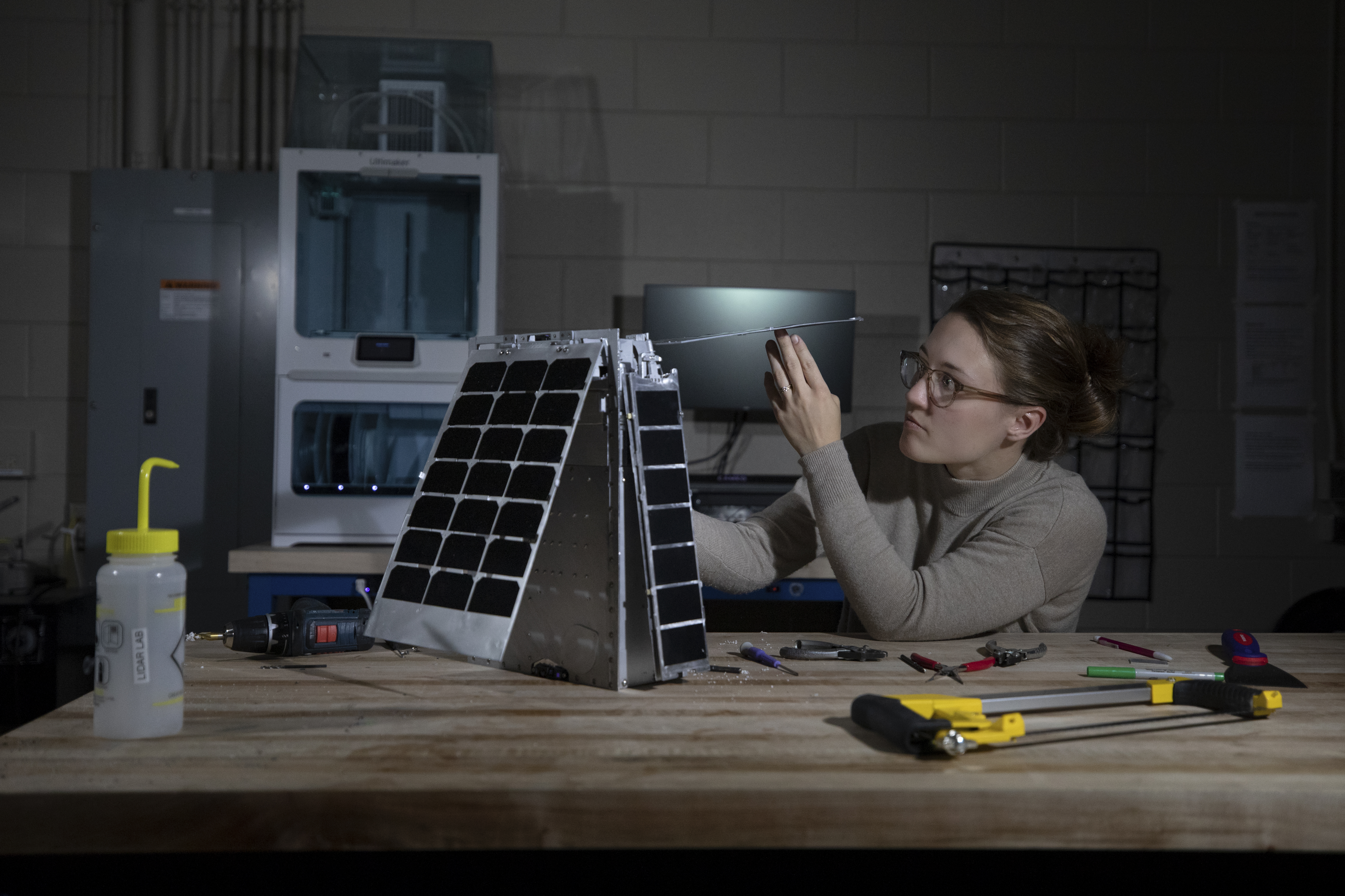 Mary Kate Broadway adjusts the model's solar array.