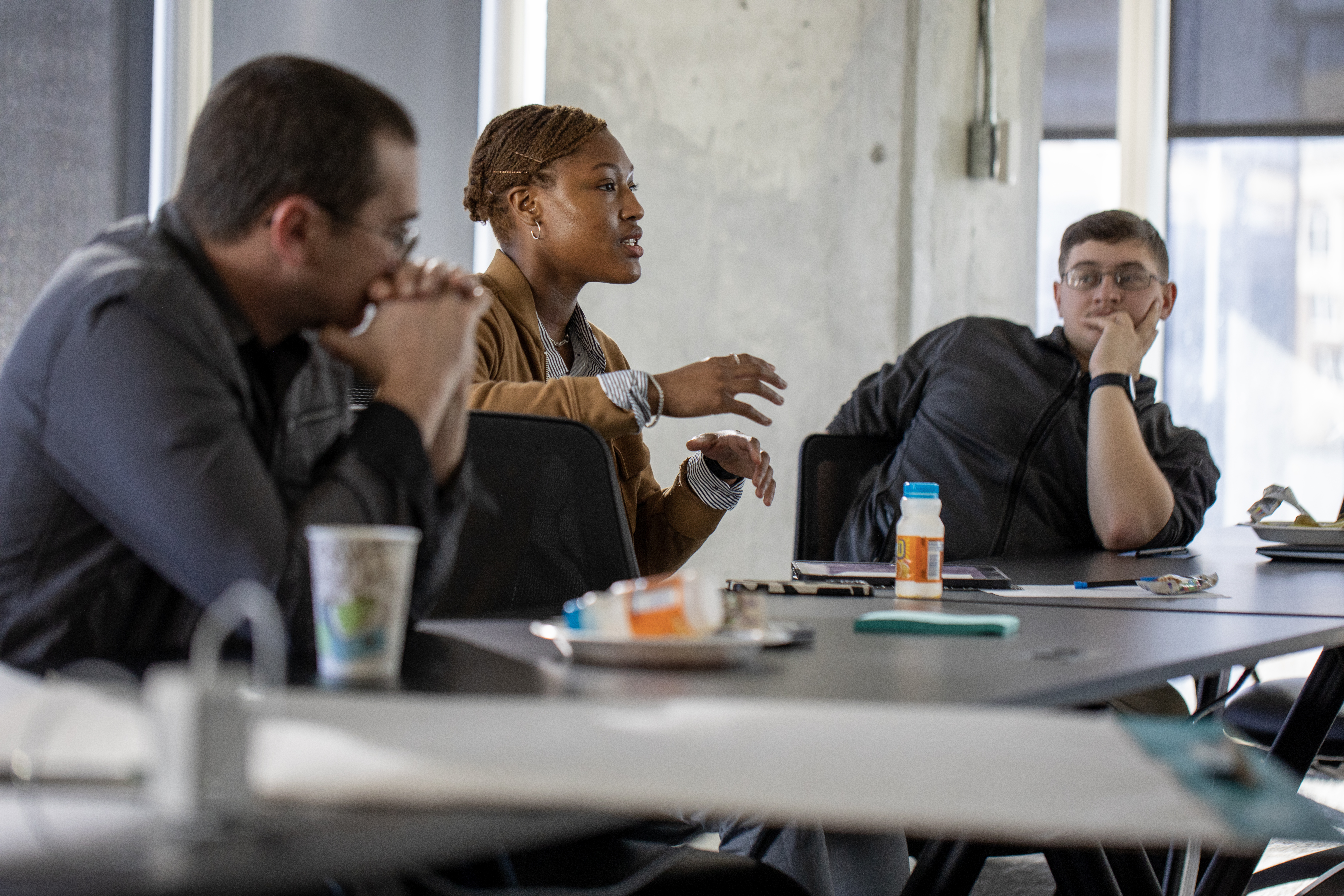 Three participants brainstorm how to approach the weekend's main objective.