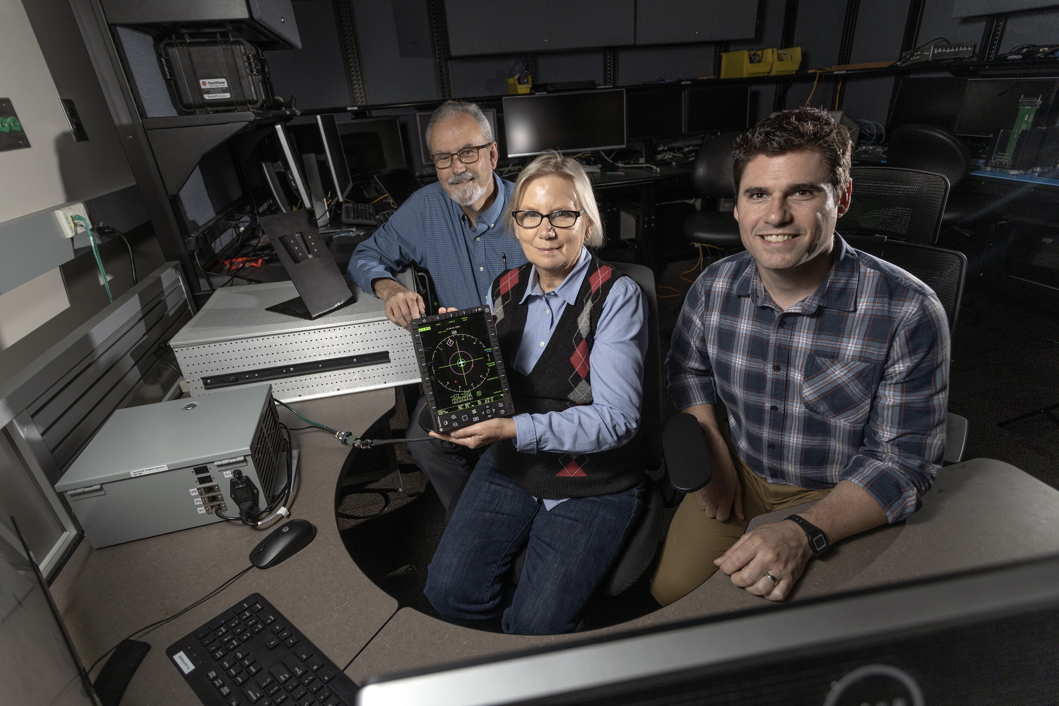 Researchers with the aircraft display developed for the Advanced Integrated Electronic Combat Suite