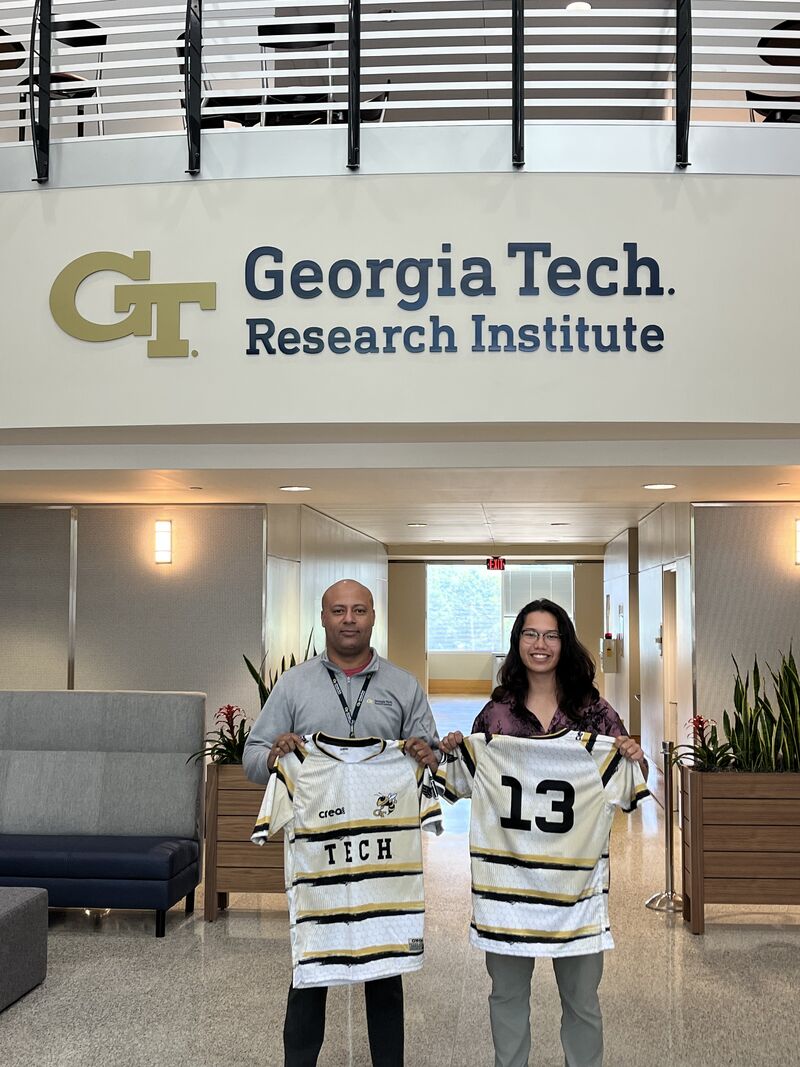 Rafael Dominguez (left) donates uniforms to Georgia Tech Men's Rugby Club President Joshua Kinoshita at GTRI Headquarters.
