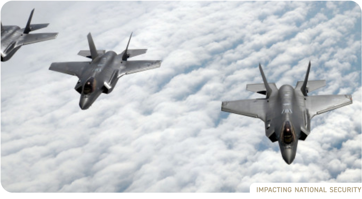 photo: Cloudy blue sky with three fighter jets in formation, shot from above