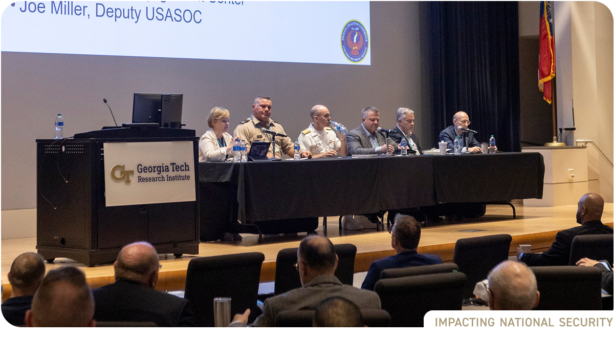 photo: Group of panelists seated at long table on stage in the GTRI auditorium