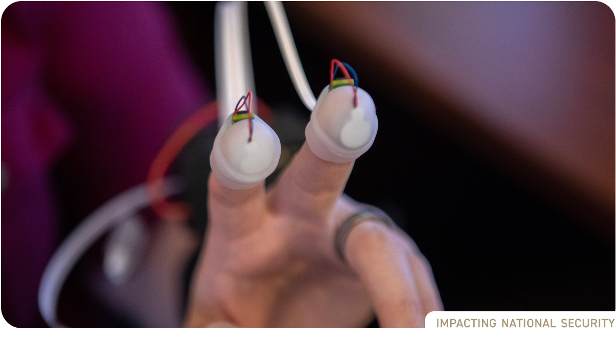 photo: plastic fingertip sensors on researcher's hand