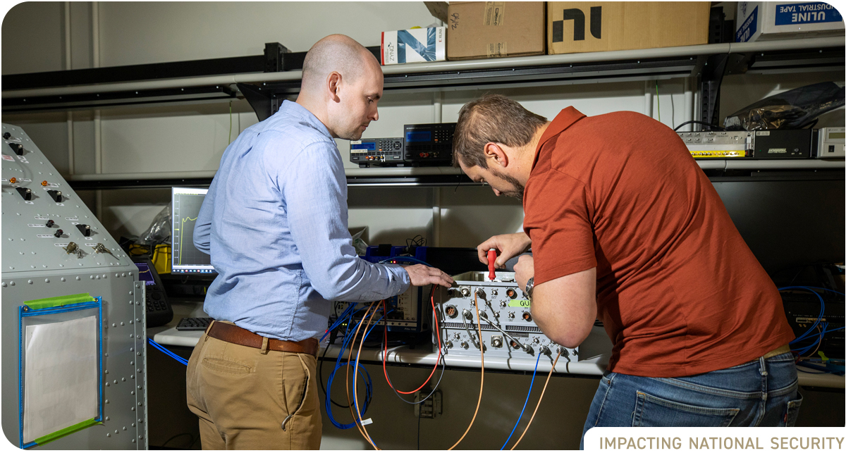 photo: two male researchers in lab working on electronic device