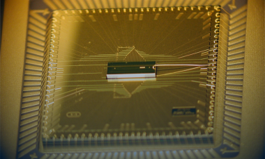 The BGA trap assembly is at the center, sitting atop the larger interposer chip that fans out the wiring. The trap chip surface area is 1 millimeter by 3 millimeters. (Credit: D. Youngner, Honeywell)