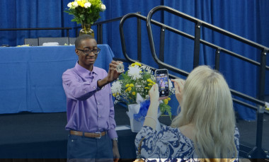 Student poses with medal. 