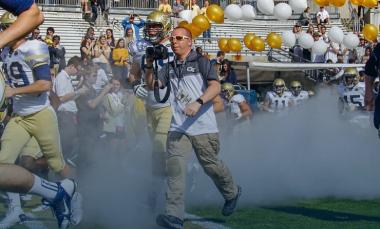 Danny Karnik runs out of the tunnel with the football team to capture a photo during the game against UGA in 2015 (Photo by Brett Davis).