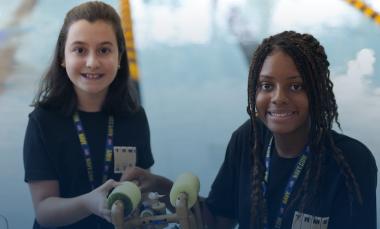 Two students pose with underwater robot