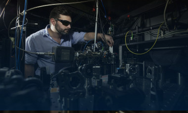 Researcher checks alignment of Doppler cooling beam