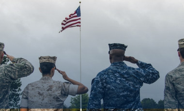 Soldiers saluting the American flag. 