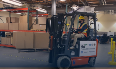 A photo of a forklift driver in a warehouse. 