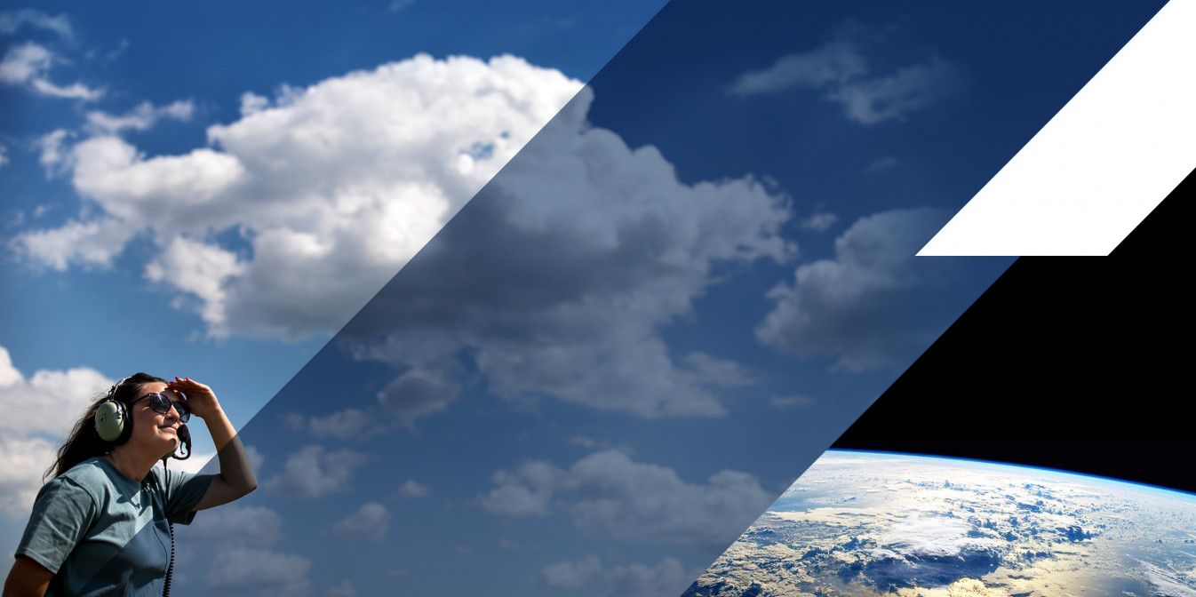 GTRI researcher wearing sunglasses and ear protection looking into blue sky with clouds