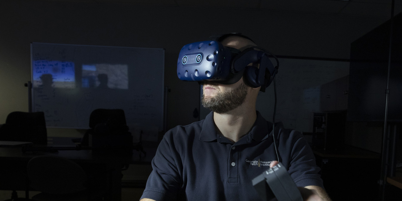 Researcher in lab wearing virtual reality goggles