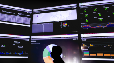 six monitors of information with person in front