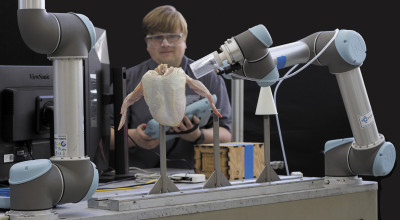 Konrad Ahlin with a "cone-loading" robot, a breakthrough in poultry technologies.