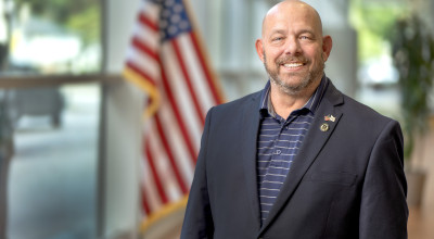 GTRI employee standing in front of American flag