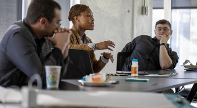 Three participants brainstorm how to approach the weekend's main objective.