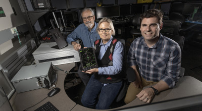 Researchers with the aircraft display developed for the Advanced Integrated Electronic Combat Suite