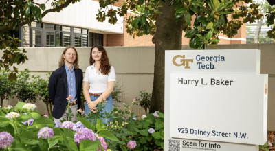 Two GTRI researchers pose for a photo outside of a GTRI facility. 