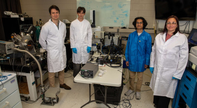 A photo of four researchers pose for a photo in a GTRI lab. 
