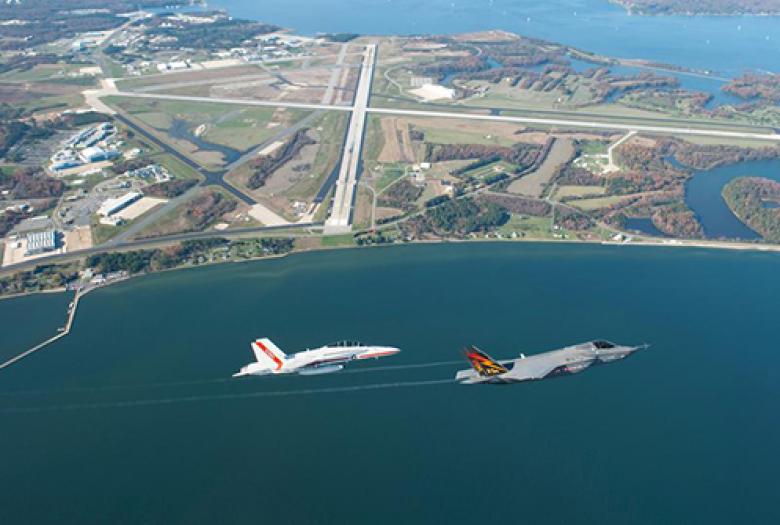 Two airplanes flying over bay