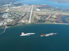 Two airplanes flying over bay